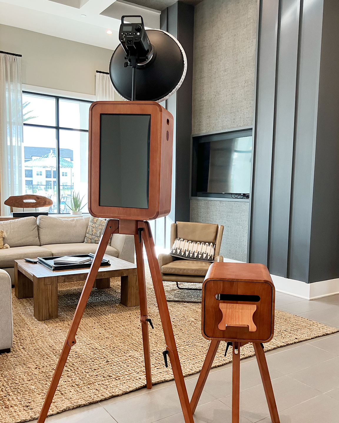 Luxury wooden wedding photo booth and matching printer setup in a modern Tampa event lounge